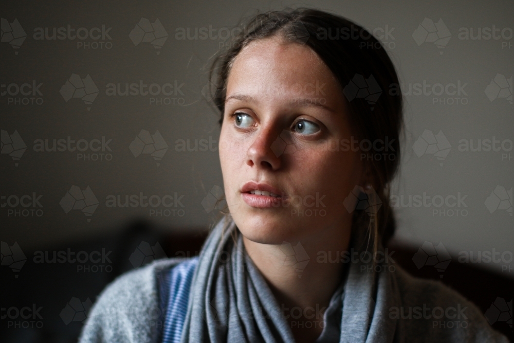 Portrait of a young teenage girl indoors with a serious expression - Australian Stock Image