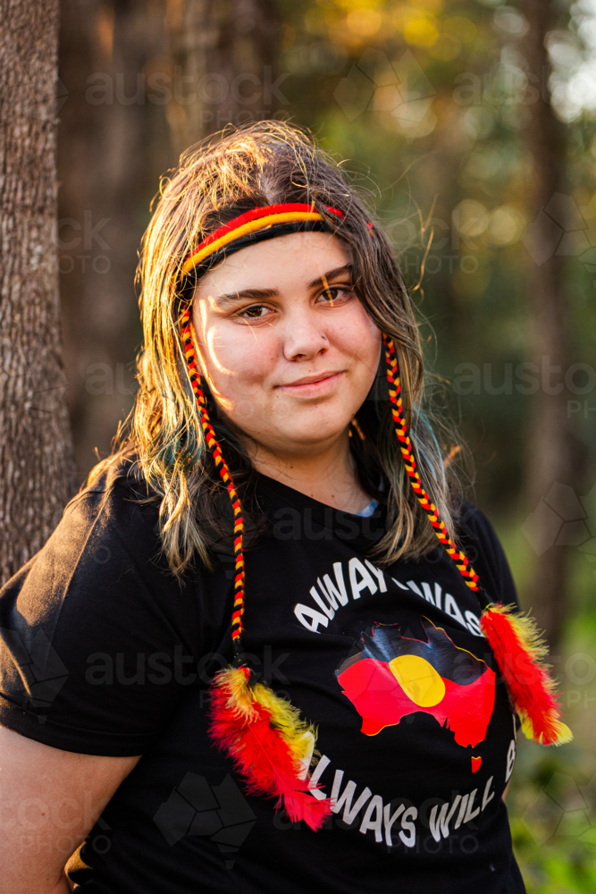 Portrait of Aboriginal Australian teenaged girl in golden light in bushland - Australian Stock Image