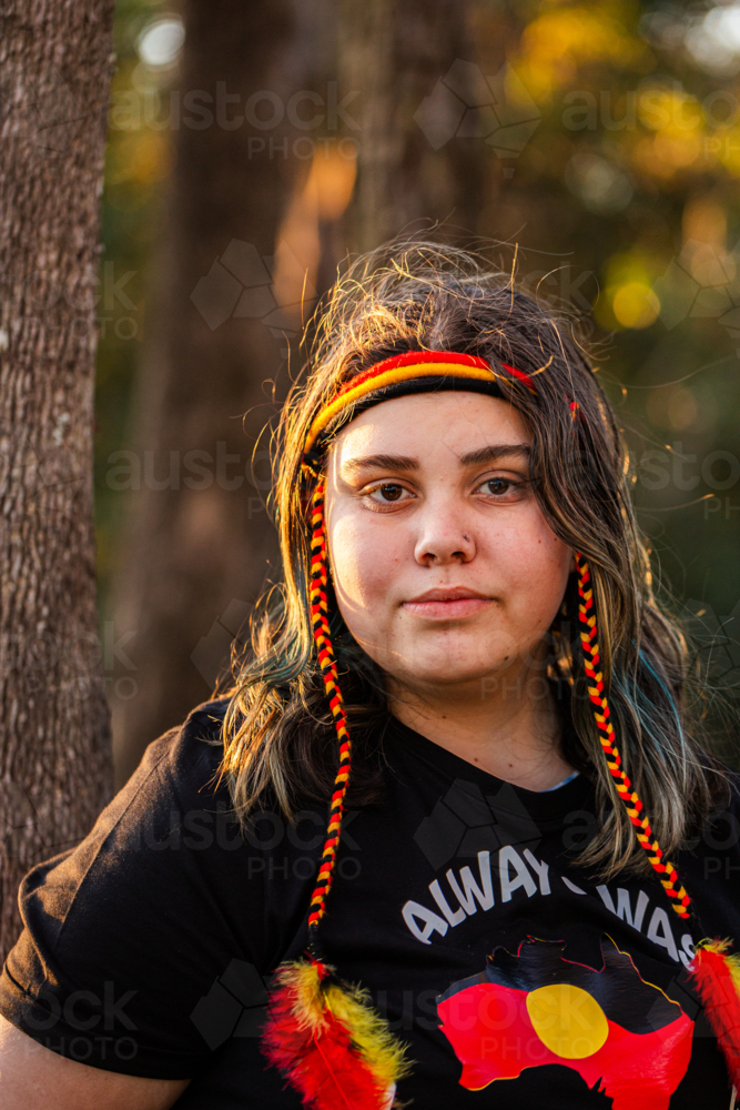 Portrait of Aboriginal Australian teenaged girl in golden light in bushland - Australian Stock Image