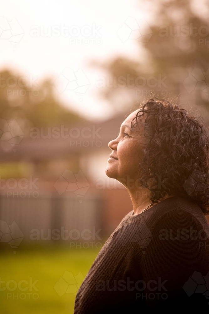 Portrait of Aboriginal woman in backyard - Australian Stock Image