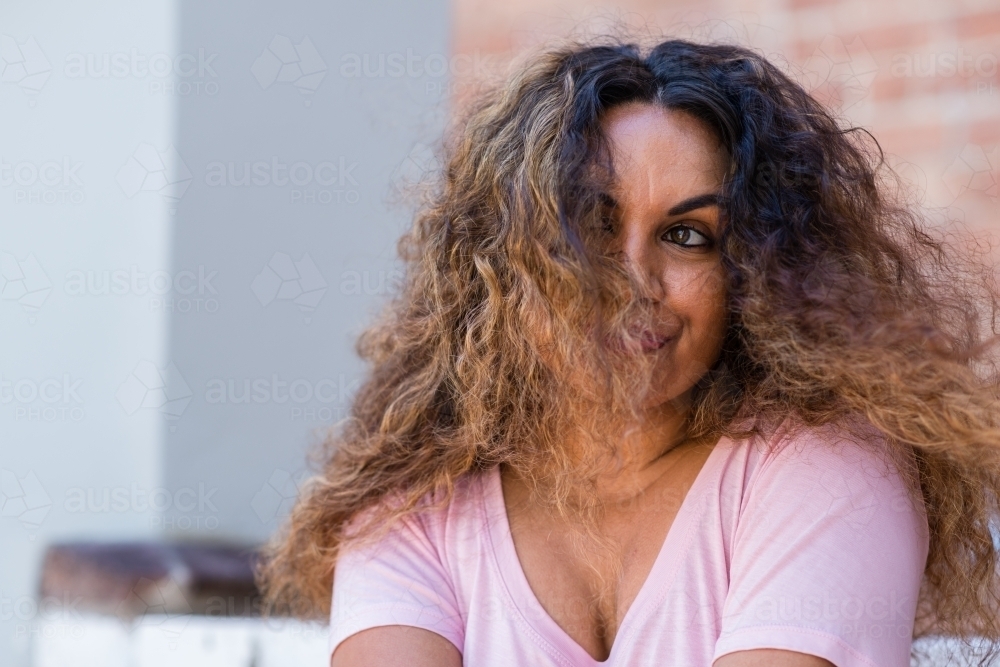portrait of aboriginal woman with hair over her face - Australian Stock Image