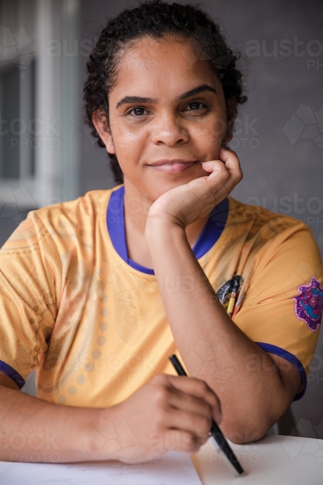 Portrait of Aboriginal woman with pen and paper - Australian Stock Image
