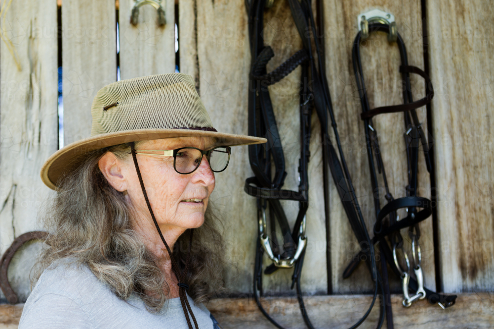 Portrait of an older woman with hat and glasses in front of - Australian Stock Image