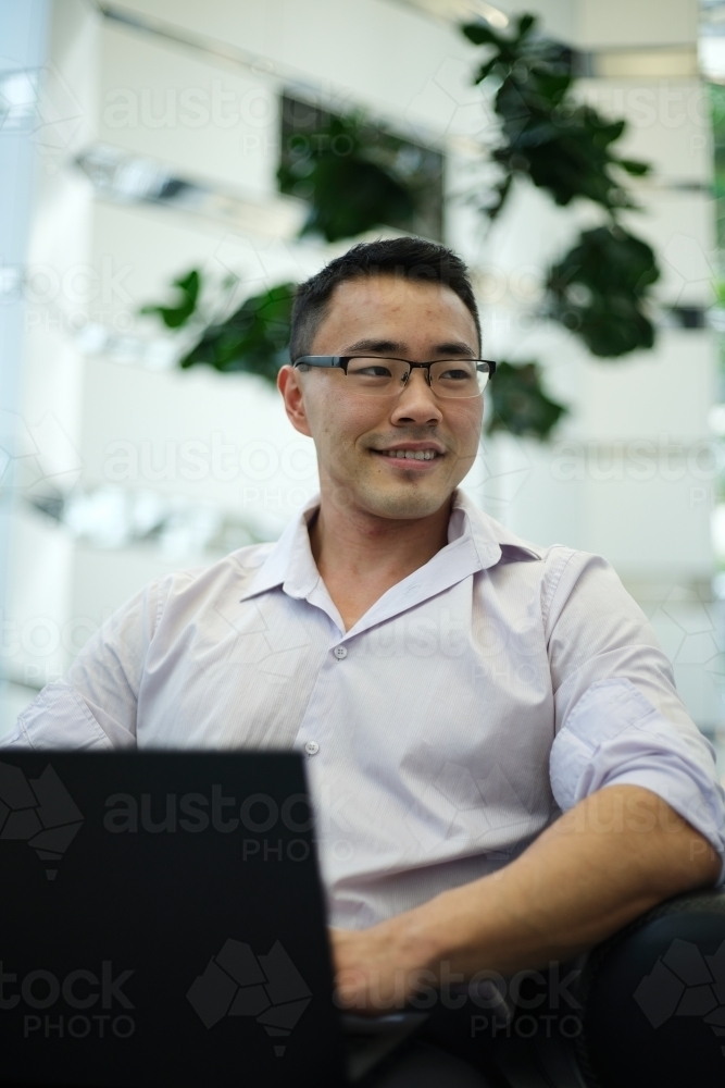 Image of Portrait of Asian businessman on laptop in a workplace ...