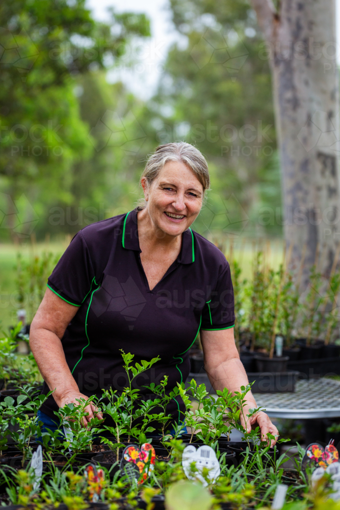 Portrait of Australian female horticulturalist gardening in freshly potted seedling nursery garden - Australian Stock Image