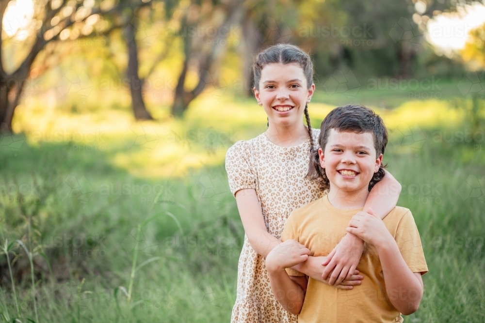 Portrait of bother and sister standing together in Australian country bush setting - Australian Stock Image