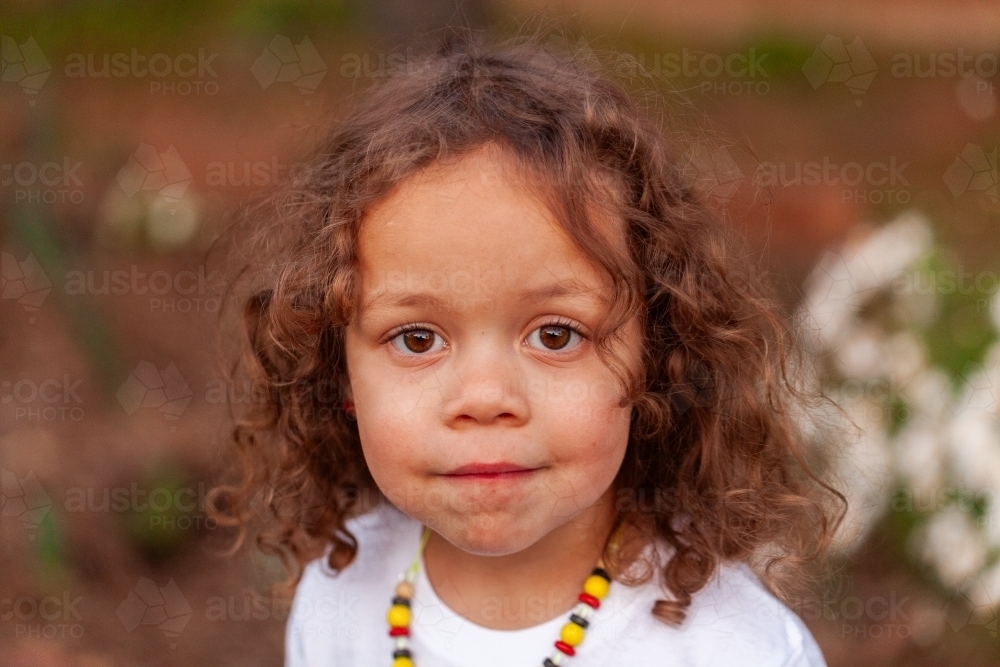 Portrait of curly haired Australian three year old child of aboriginal ethnicity - Australian Stock Image