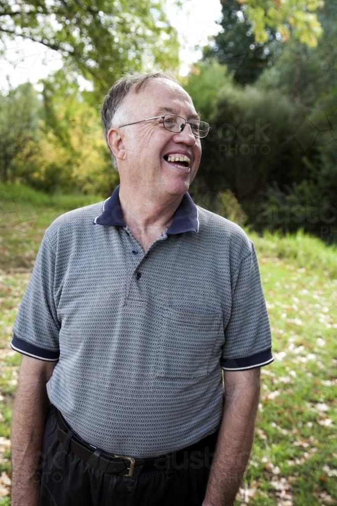 Portrait of disabled man standing outside laughing - Australian Stock Image
