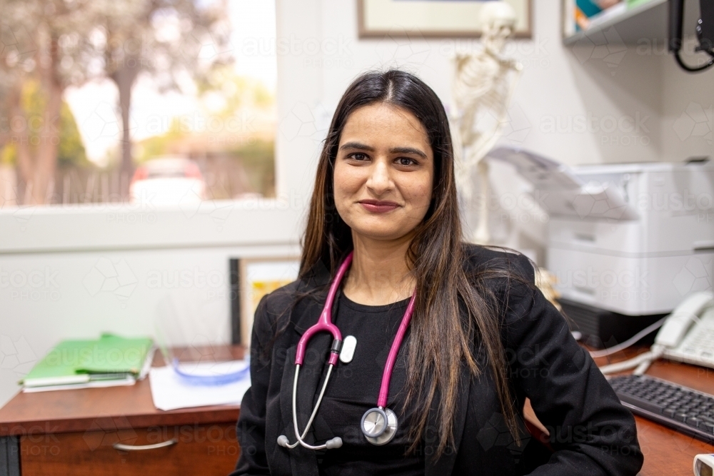 portrait of female doctor in her medical office looking at camera smiling - Australian Stock Image
