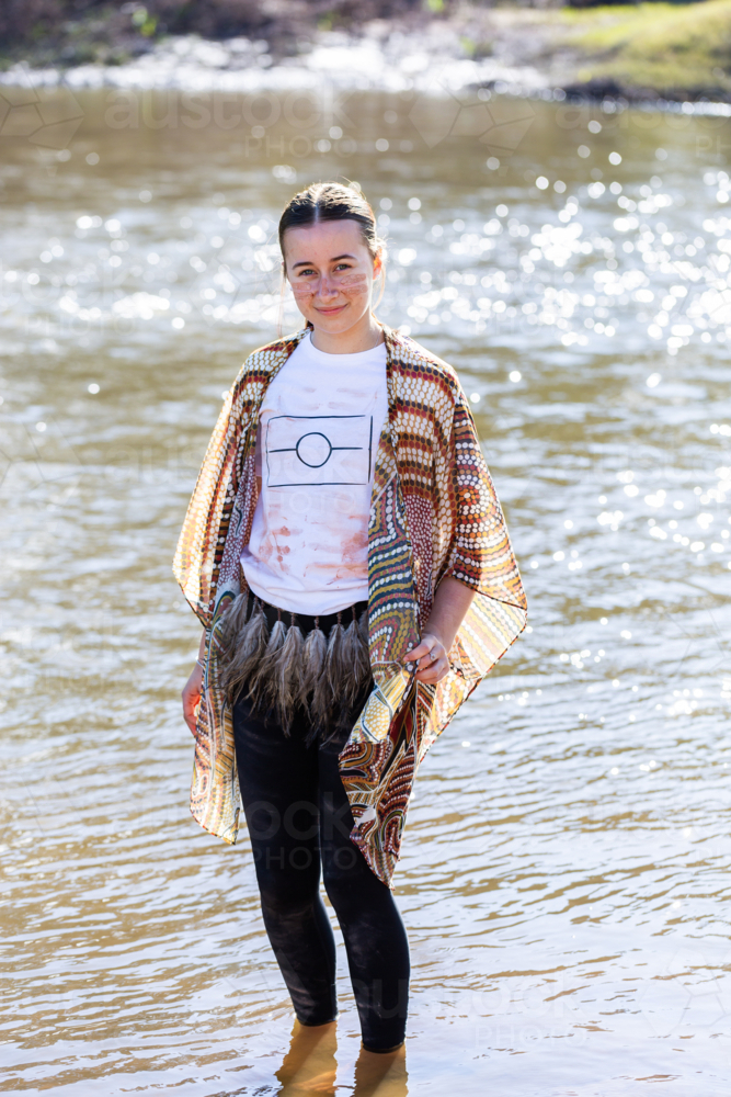Portrait of First Nations Australian teen girl against sparkling water of inland river - Australian Stock Image