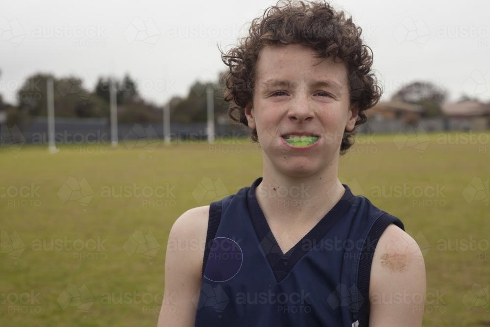 Portrait of Grassroots Footy player smiling with mouthguard - Australian Stock Image