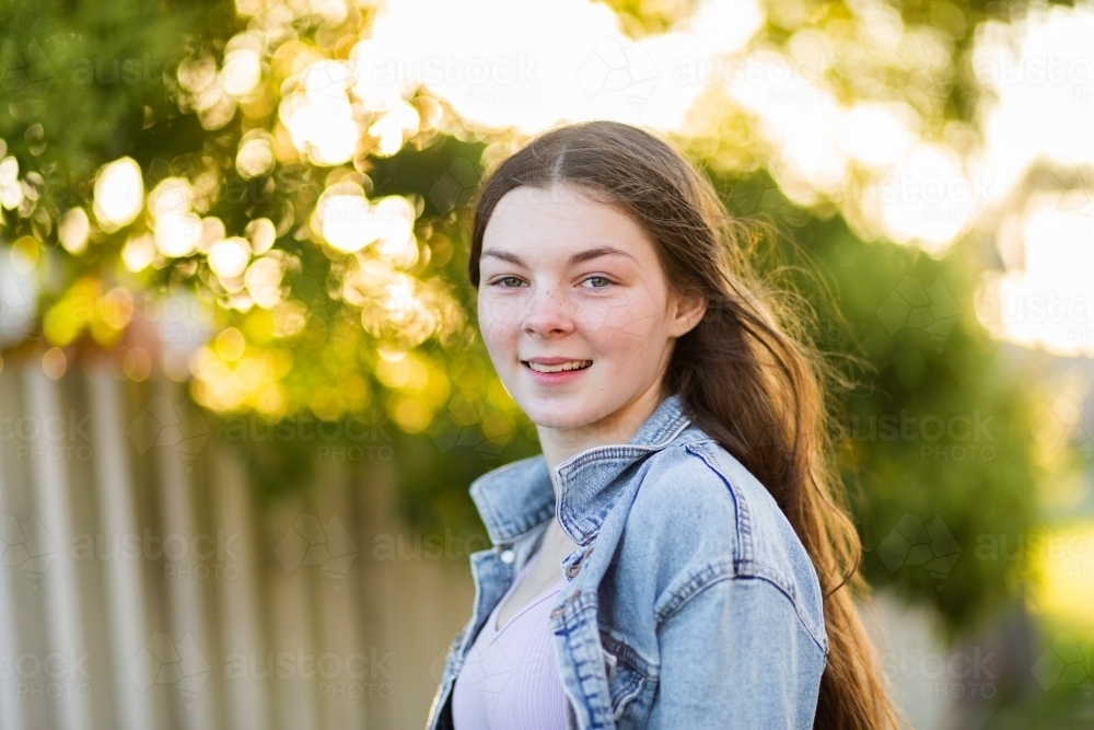 Portrait of happy 14 year old girl with bokeh background - Australian Stock Image