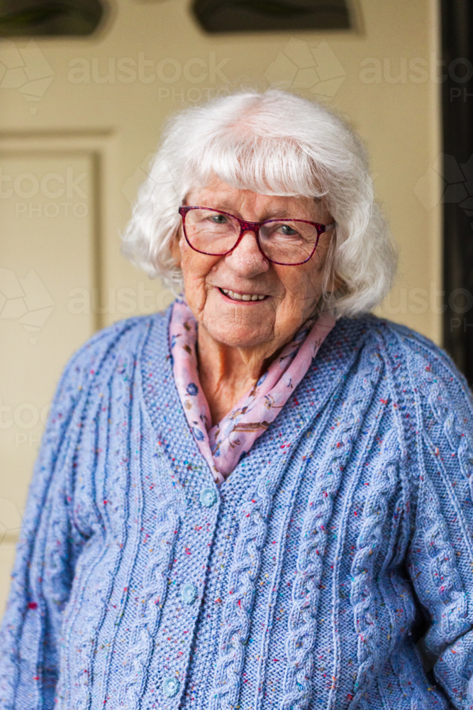 Portrait of happy 99 year old elderly Australian woman standing by front door of her home - Australian Stock Image