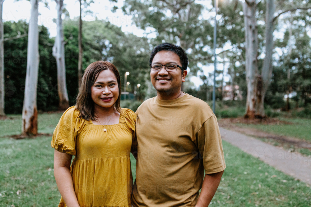 Image of Portrait of happy Asian couple standing at the park - Austockphoto