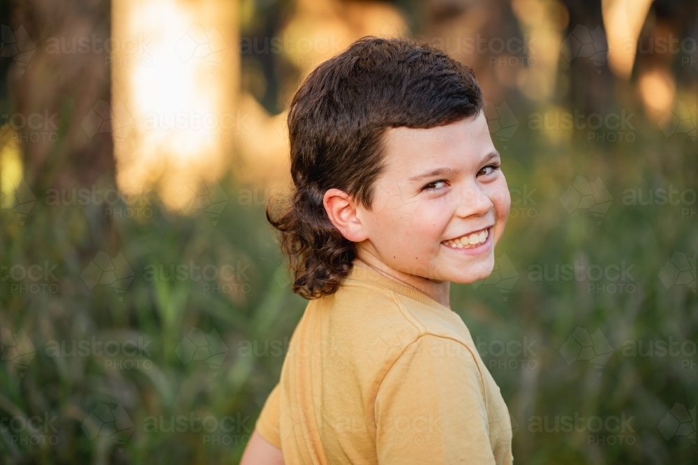 Portrait of happy boy wearing yellow shirt in Australian country bush setting - Australian Stock Image