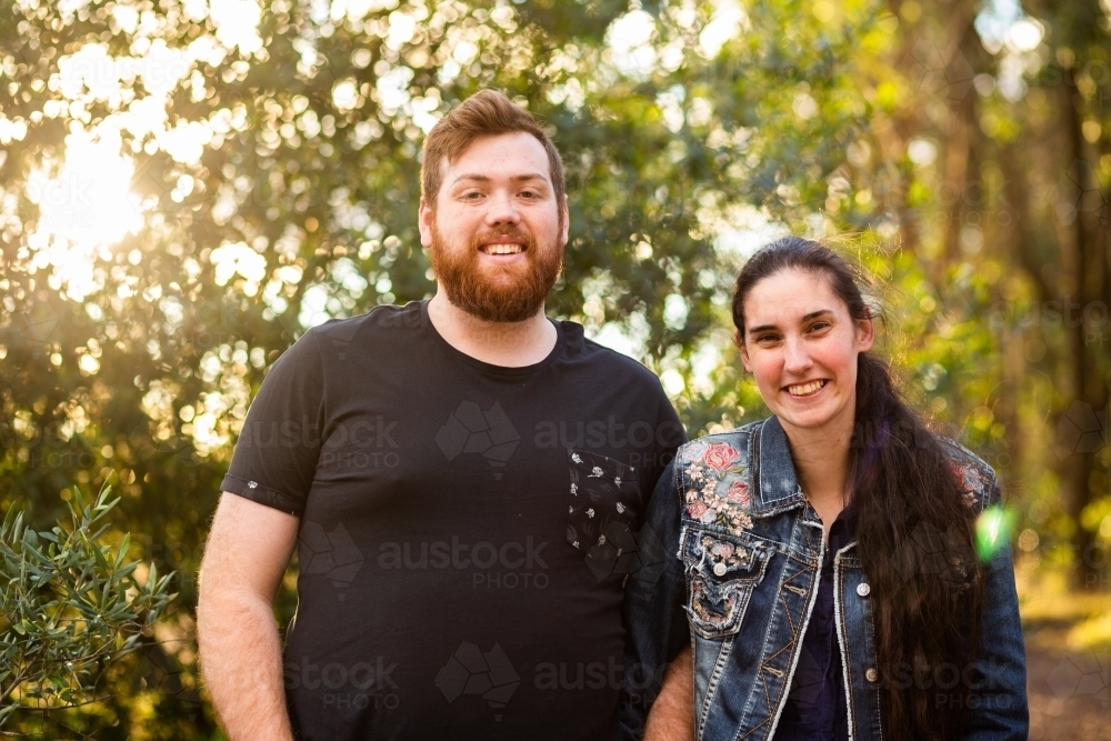 Portrait of happy couple side by side outside in casual clothing - Australian Stock Image