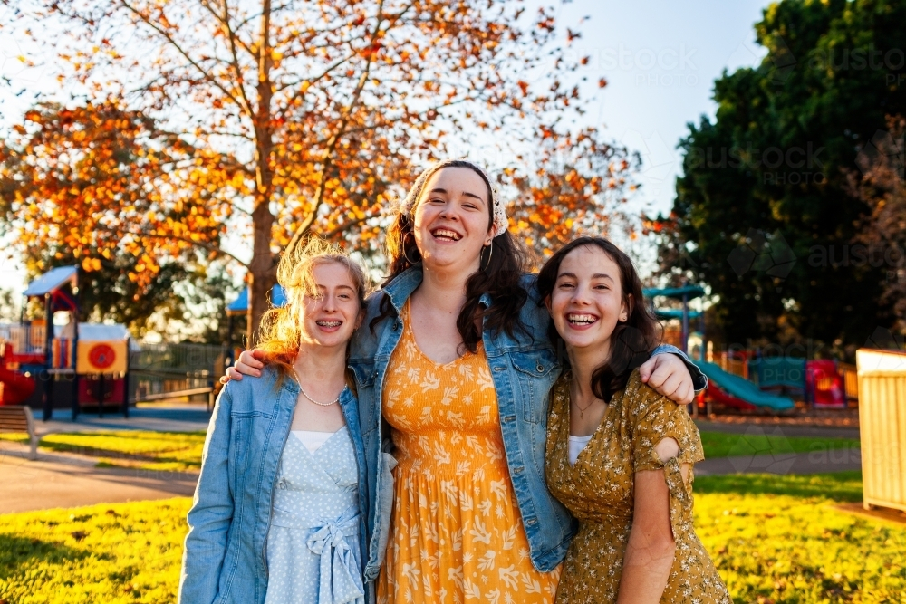 Portrait of happy group of three teen friends laughing together - Australian Stock Image