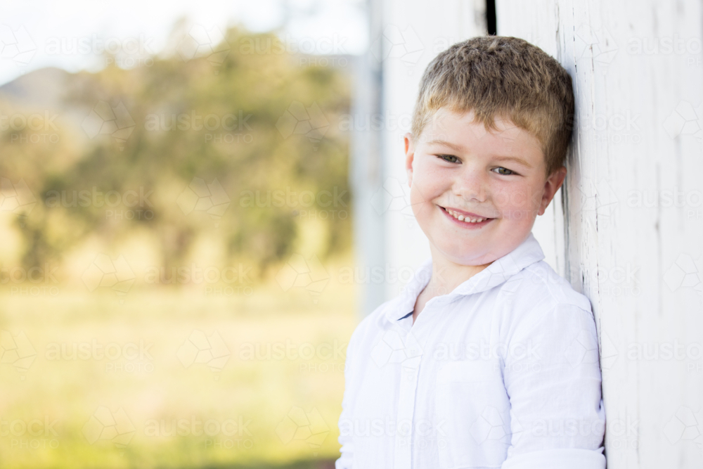 Portrait of happy little boy smiling on farm - Australian Stock Image
