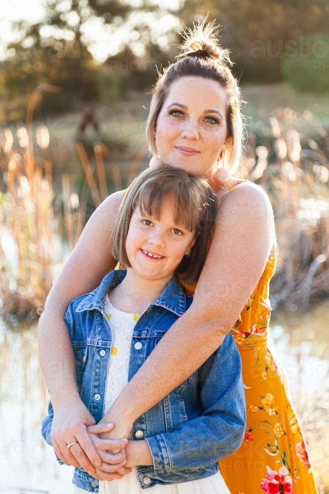 Portrait of happy mother in her thirties with daughter outside - Australian Stock Image