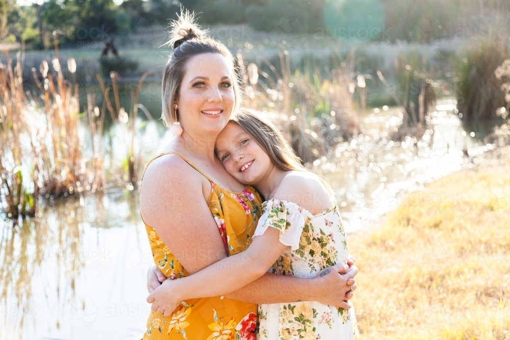 Portrait of happy mother in her thirties with daughter outside - Australian Stock Image