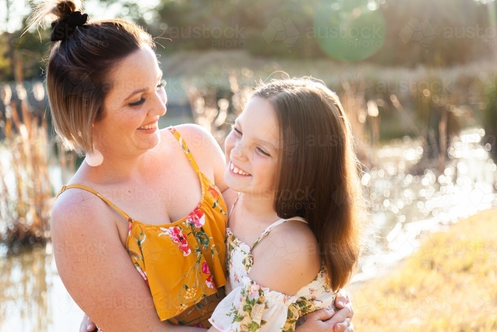 Portrait of happy mother in her thirties with daughter outside - Australian Stock Image