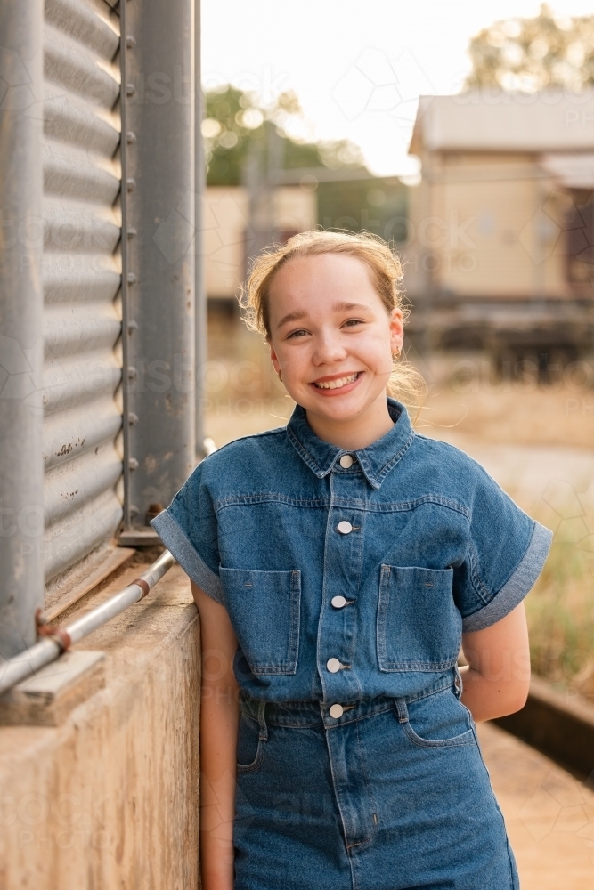 Portrait of happy pre-teen girl in rustic country setting - Australian Stock Image