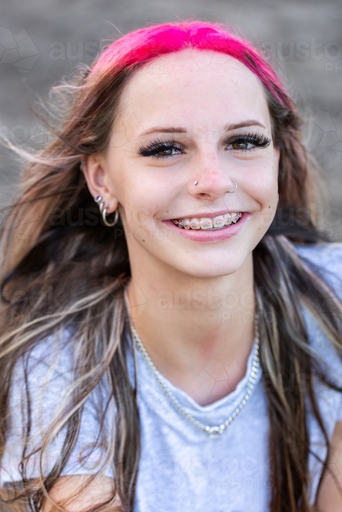 Portrait of happy teen girl with pink hair and braces - Australian Stock Image