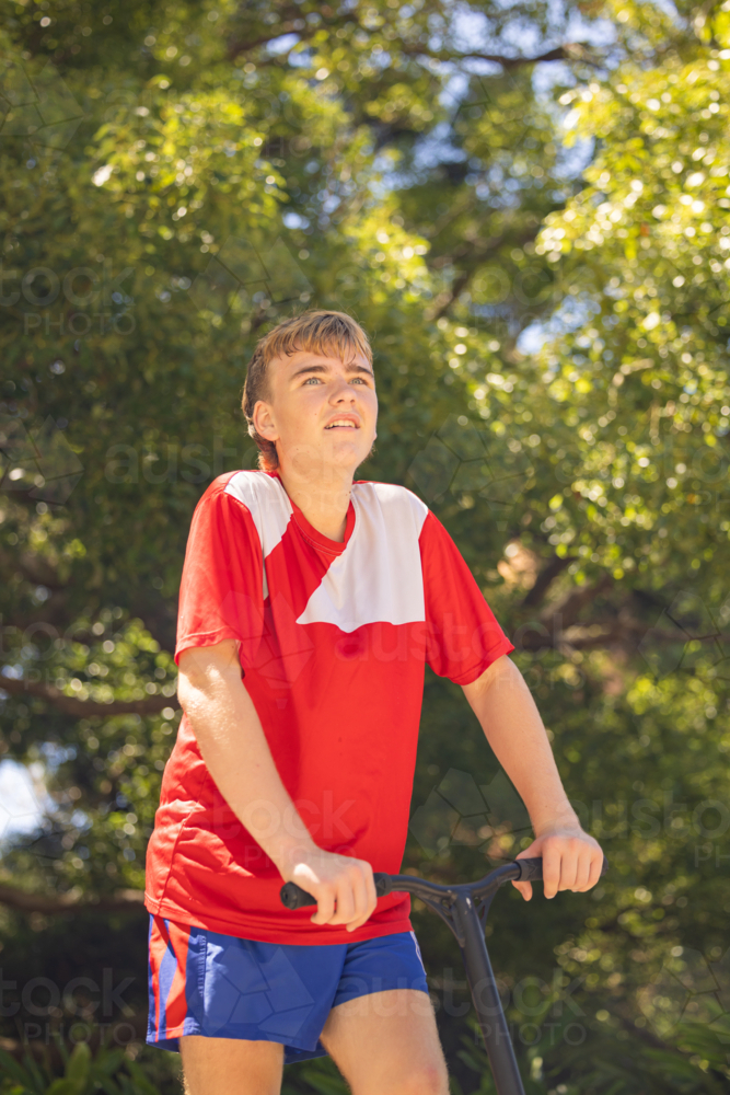 Image of Portrait of happy teenage boy standing with scooter at skate ...