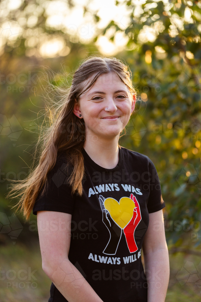 Portrait of happy teenaged girl in Aussie bushland at sunset - Australian Stock Image