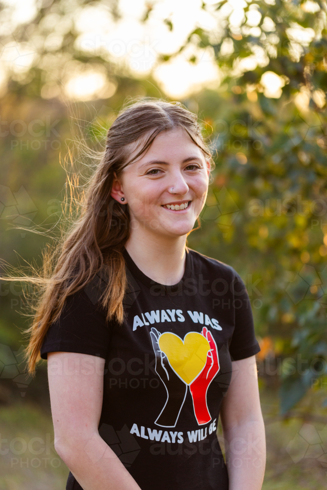 Portrait of happy teenaged girl in Aussie bushland at sunset - Australian Stock Image
