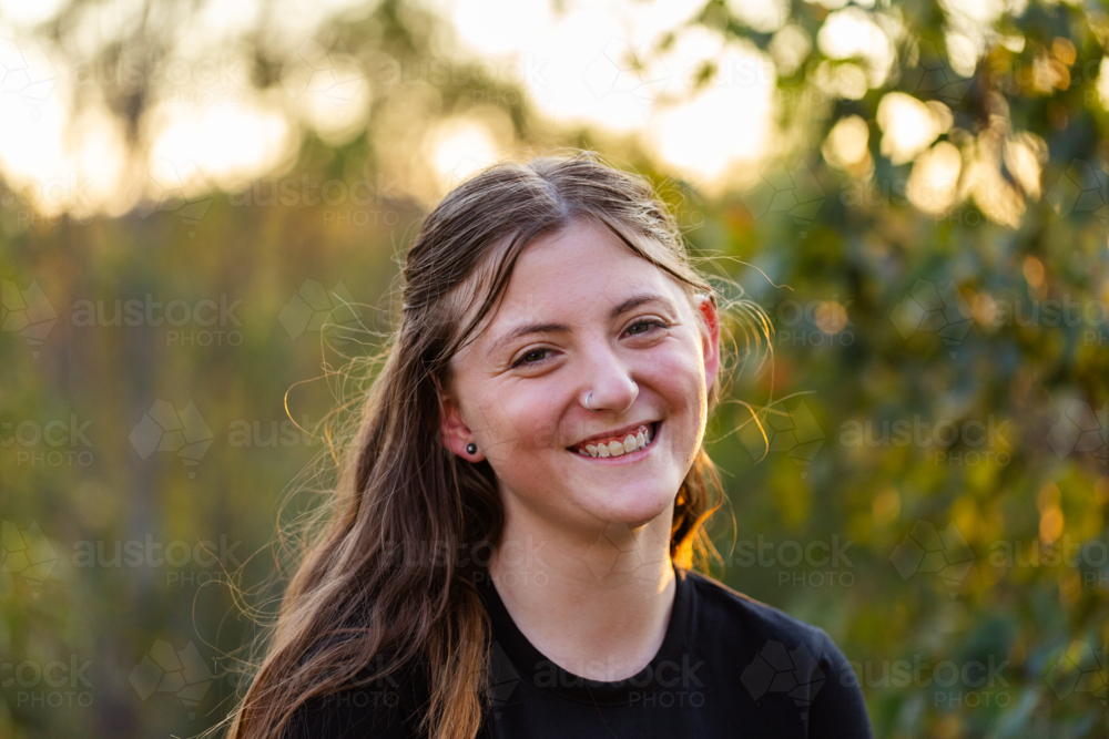 Portrait of happy teenaged girl in Aussie bushland at sunset - Australian Stock Image