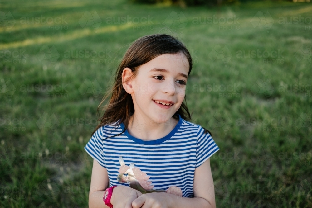Portrait of happy young girl in the park at sunset - Australian Stock Image