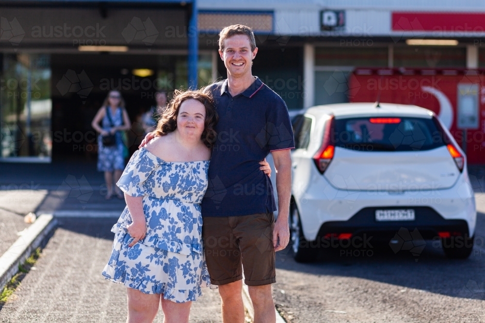 Portrait of happy young person with down syndrome and her disability worker in community - Australian Stock Image
