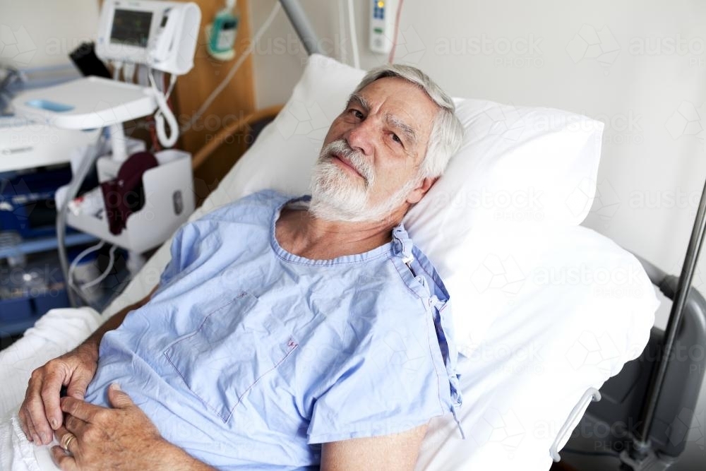Portrait of middle aged male patient lying in a hospital ward - Australian Stock Image
