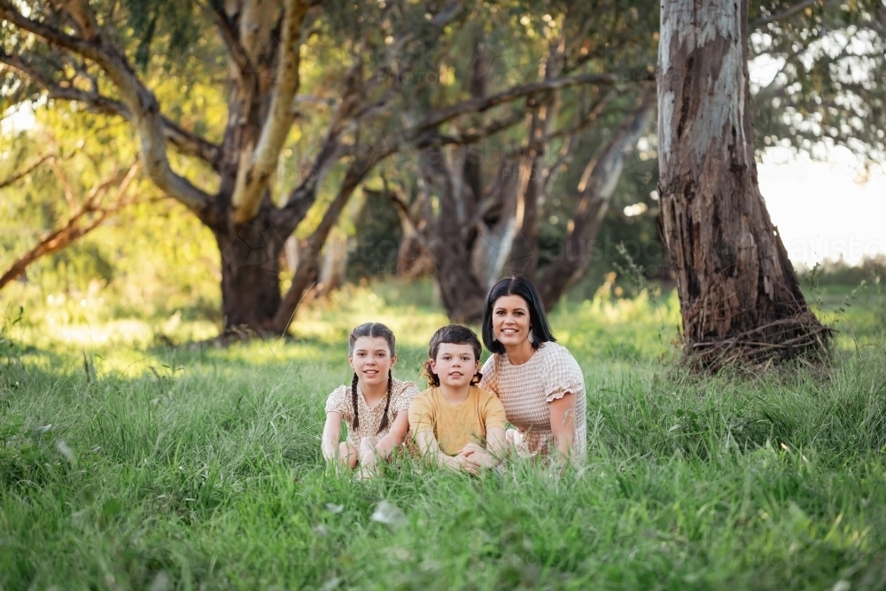 Portrait of mother and children sitting together in Australian bush setting - Australian Stock Image