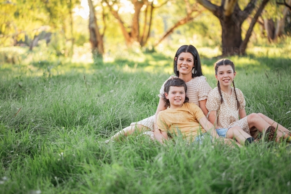 Portrait of mother and children sitting together in Australian bush setting - Australian Stock Image