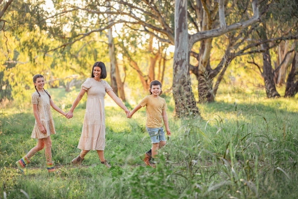 Portrait of mother and children walking together in Australian bush setting - Australian Stock Image