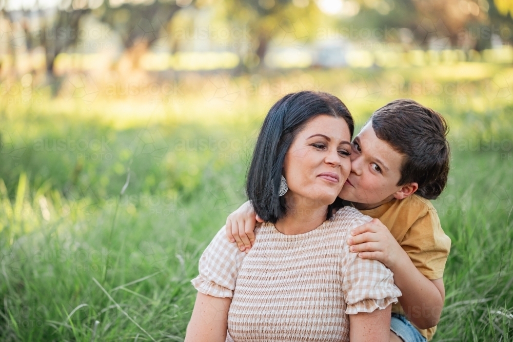 Portrait of mother and son sitting together in Australian bush setting - Australian Stock Image