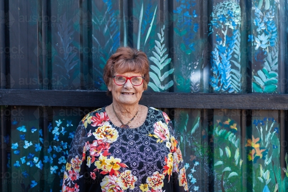 Image of Portrait of older woman in floral top in urban area - Austockphoto