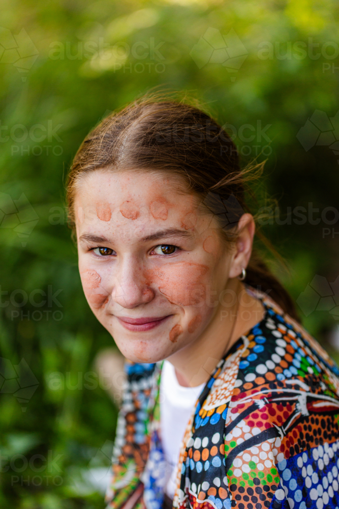 Portrait of pre-teen First Nations Australian girl in traditional aboriginal ochre face paint - Australian Stock Image