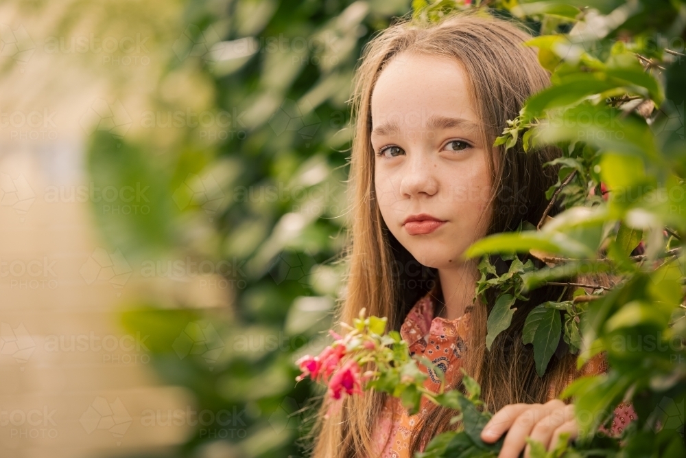 Portrait of pre-teen girl in lush garden setting - Australian Stock Image