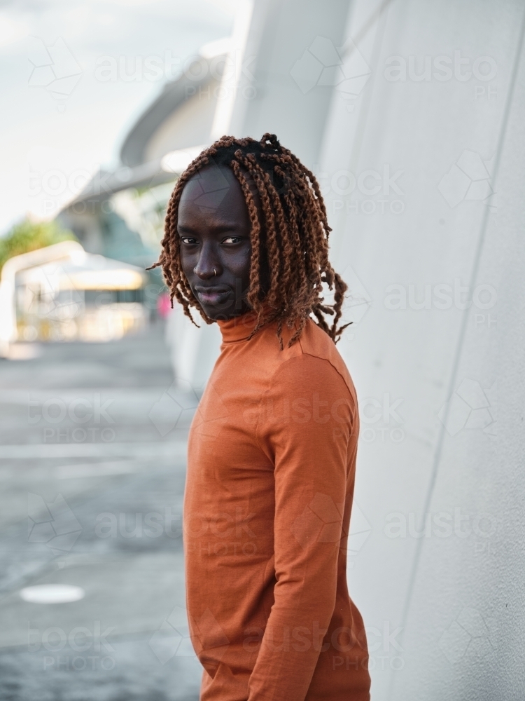 Portrait of South Sudanese man standing in front of wall - Australian Stock Image
