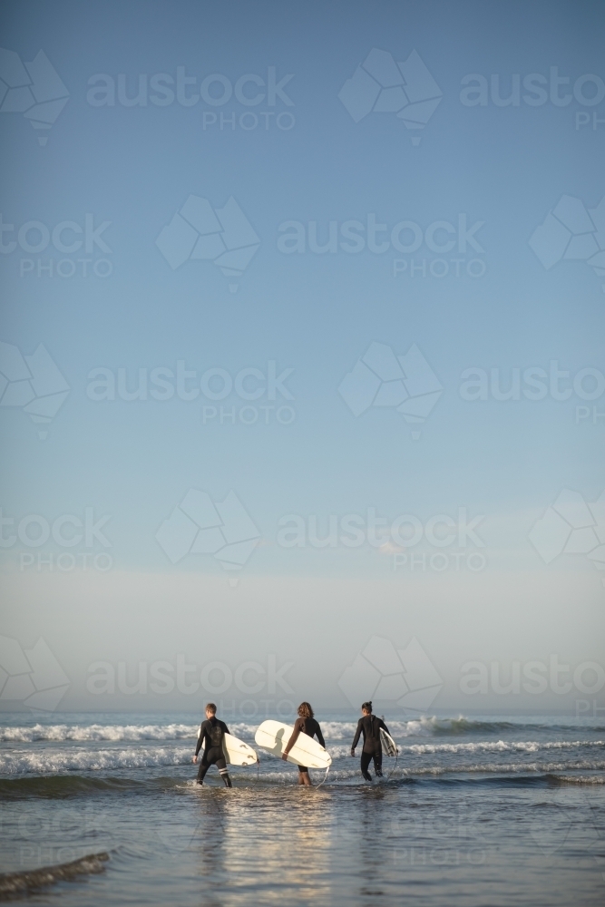 Portrait of surfers walking in water - Australian Stock Image