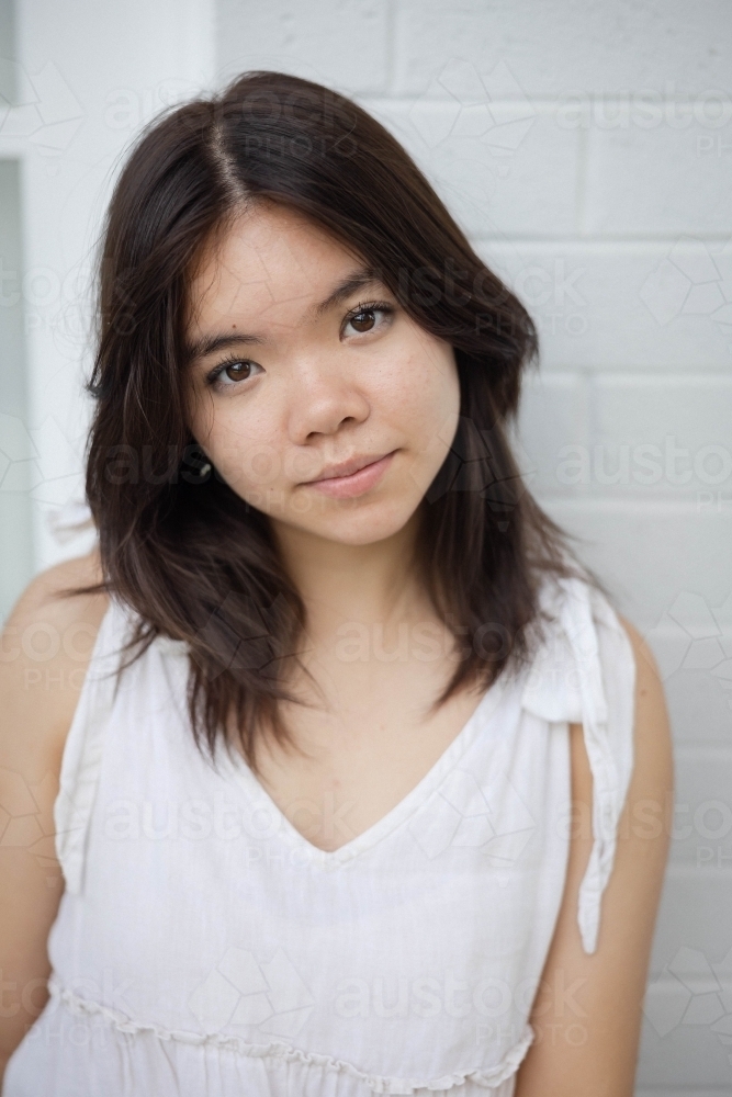 Portrait of teenage girl wearing white dress - Australian Stock Image
