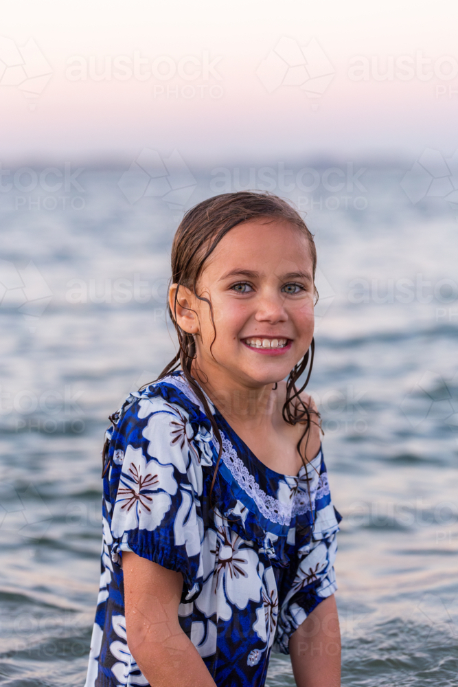 Portrait of Torres Strait Islander child swimming in ocean water at dusk - Australian Stock Image