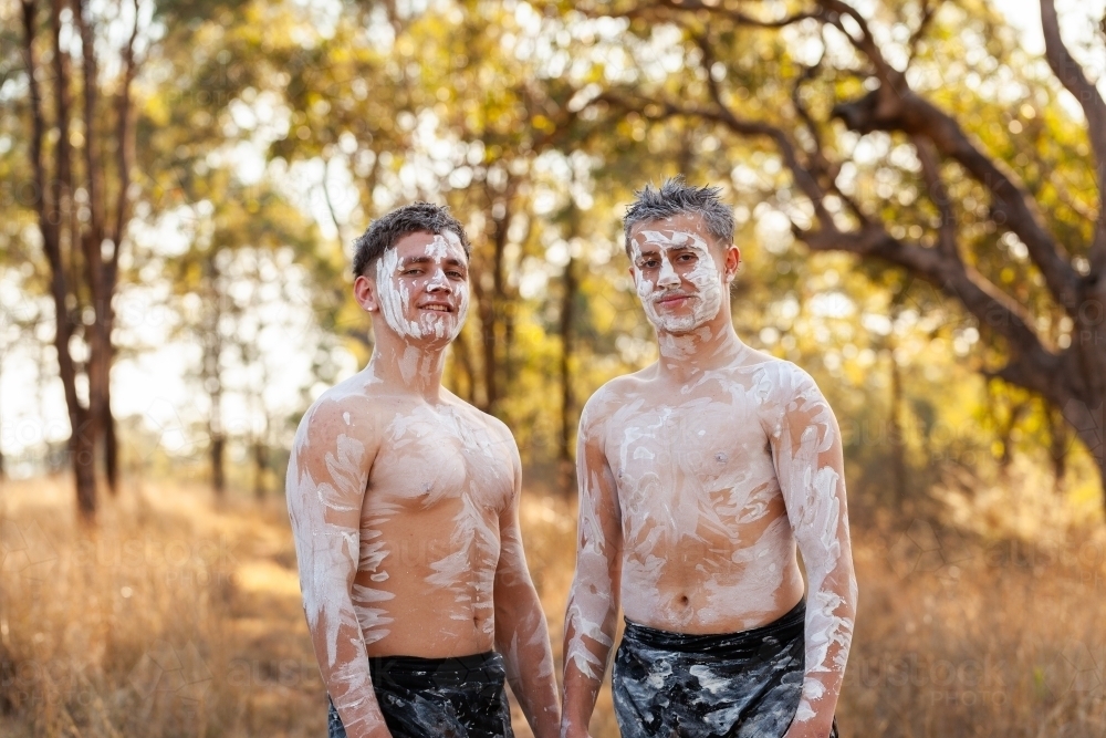 Portrait of two happy Aboriginal teen boys in ochre body paint - Australian Stock Image
