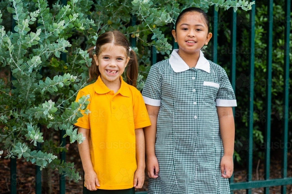 Portrait of two happy school girls looking forward to going back to school - Australian Stock Image