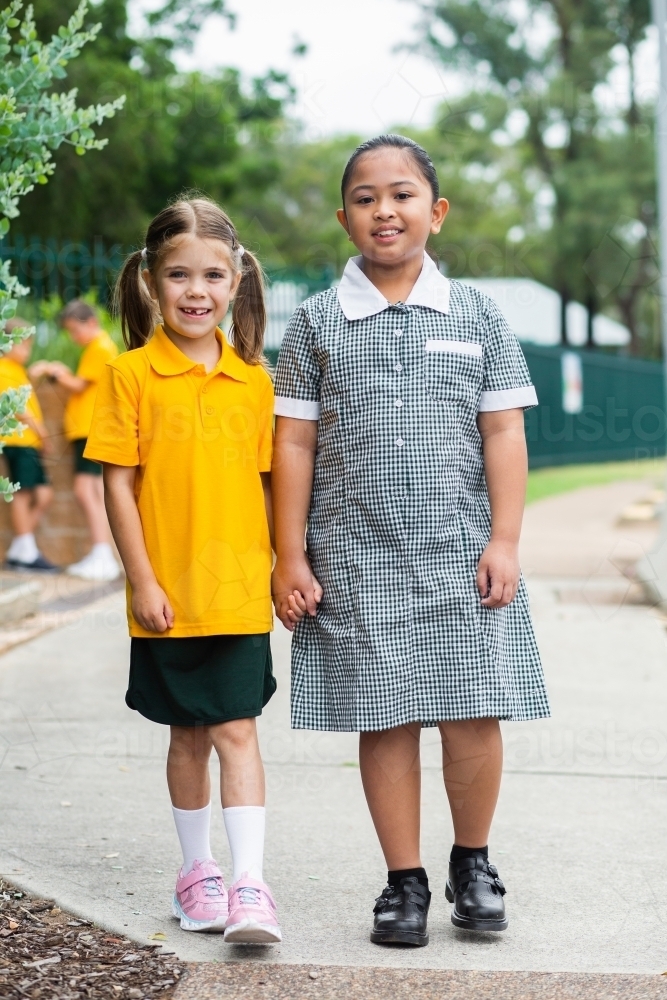 Portrait of two happy school girls looking forward to going back to school - Australian Stock Image
