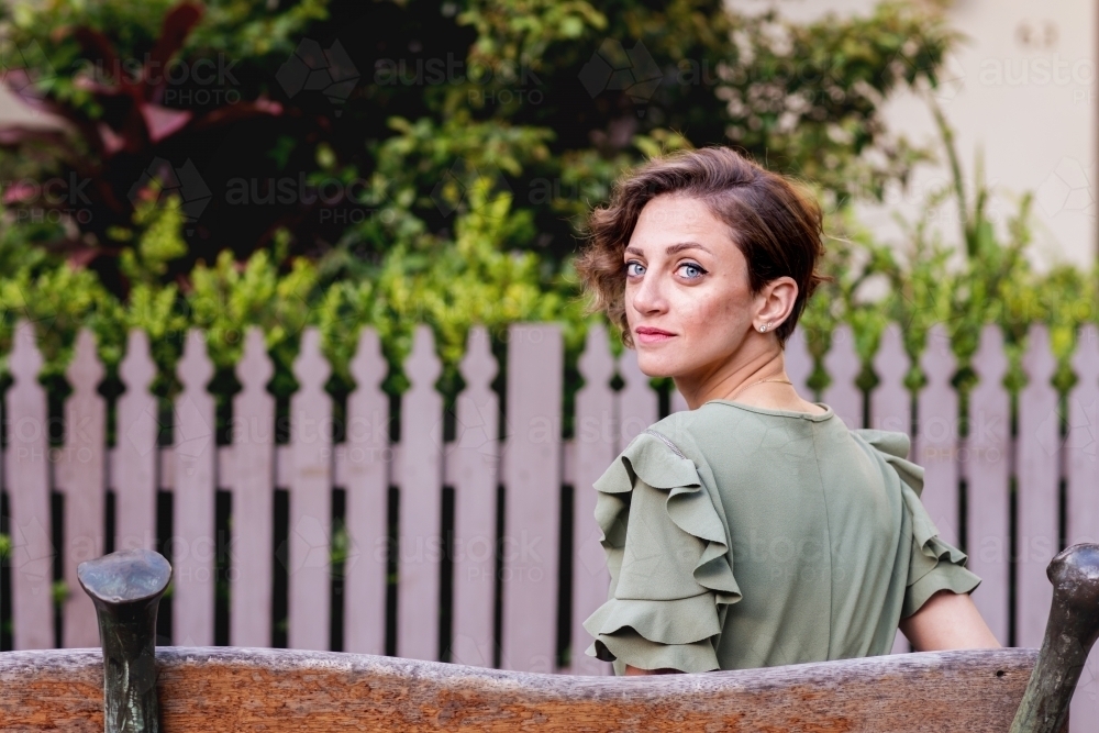 portrait of woman sitting on a bench in the city - Australian Stock Image