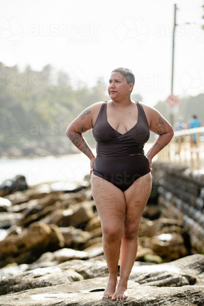 portrait of woman with tattoos at the poolside in summertime - Australian Stock Image